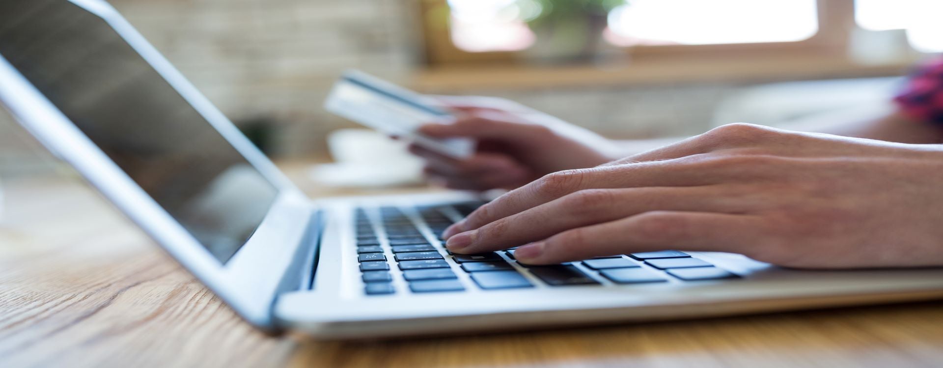 Hands Holding Payment Card by Laptop